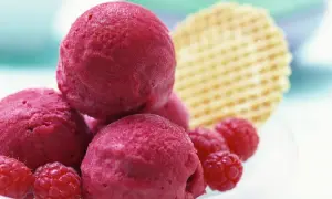 Himbeer Sorbet Kugeln mit frischen Himbeeren und Waffel. Ein erfrischender Genuss für heiße Tage.