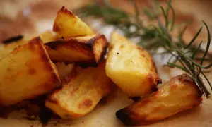 Knusprige Kartoffeln aus dem Ofen, goldbraun und mit Rosmarin verfeinert, verlocken zum Zugreifen.