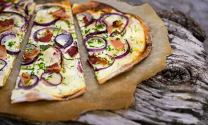 Flammkuchen mit Zwiebeln, Speck und Schnittlauch. Ein klassisches rezept flammkuchen belag, das immer schmeckt.