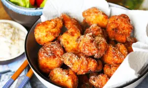Knuspriges Chicken Karaage in einer Schüssel, daneben eine Dip-Schale und Salat. Perfekt für einen Snack!