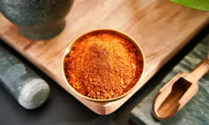 Schüssel mit scharfem Chilipulver, eine tolle pul biber alternative. Mörser und Holzschaufel daneben.
