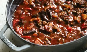 Herzhaftes Gulasch mit Paprika und Zwiebeln, eine köstliche Daube Provençale, dampft in einem grauen Gusseisentopf.