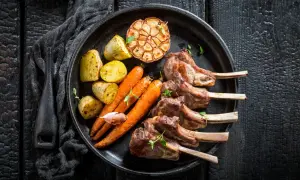 Saftiges Lammkarree mit Rosmarinkartoffeln, Karotten und geröstetem Knoblauch – das beste Rezept für einen Festtagsschmaus.