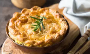 Goldbrauner, knuspriger Pot Pie mit Rosmarinzweig, bereit zum Servieren.