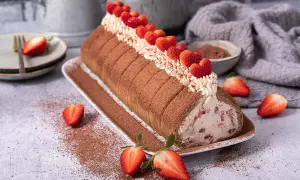 Erdbeer Tiramisu Rolle mit frischen Erdbeeren und Kakao bestäubt, ein Genuss für Augen und Gaumen.