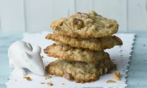 Ein Stapel leckerer cookies mit haferflocken und schokolade, daneben eine kleine weiße Maus-Dekoration.