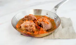 Saftige Daube de boeuf mit Karotten in einer Pfanne, serviert auf einem Leinentuch.
