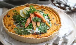 Herzhafte quiche mit pfifferlingen, garniert mit Erbsen, Karotten, Zitrone und Kräutern. Ein frühlingshafter Genuss!