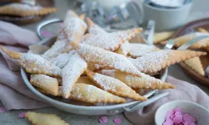 Leckere, knusprige Mutzen, bestäubt mit Puderzucker, warten auf Genießer. Was sind Mutzen? Diese frittierten Teigteilchen sind ein süßer Genuss!