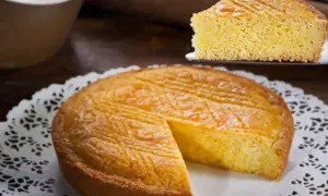 Ein goldbraunes Gateau Breton mit einem Stück auf einem Tortenheber.