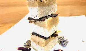 Gestapelte Scheiben Millionaire Shortbread mit Schokoladenglasur, dekoriert mit Lavendel und Blütenblättern.