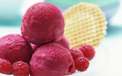 Himbeer Sorbet Kugeln mit frischen Himbeeren und Waffel. Ein erfrischender Genuss für heiße Tage.