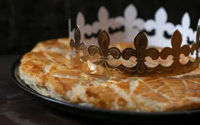 Goldene Krone auf einer goldbraunen Galette des Rois. Wer findet die Bohne und wird König?