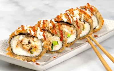 Knuspriges Sushi mit Hähnchen und Gemüse, beträufelt mit Saucen. Ein Genuss für die Sinne!