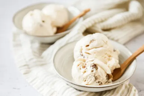 Cremiges Malaga Eis mit Rosinen, perfekt für ein selbstgemachtes Malaga Eis Rezept. Serviert in Schalen mit Holzlöffeln.