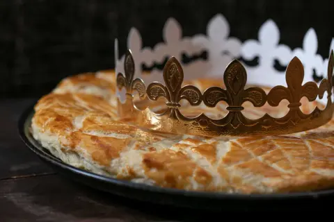 Goldene Krone auf einer goldbraunen Galette des Rois. Wer findet die Bohne und wird König?