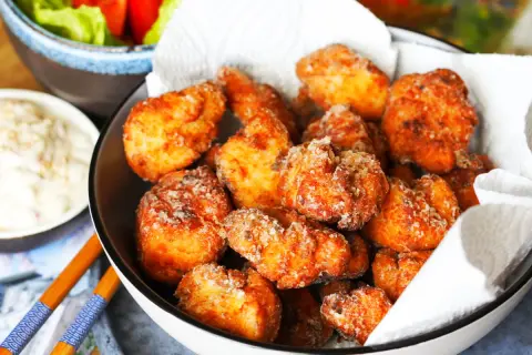 Knuspriges Chicken Karaage in einer Schüssel, daneben eine Dip-Schale und Salat. Perfekt für einen Snack!