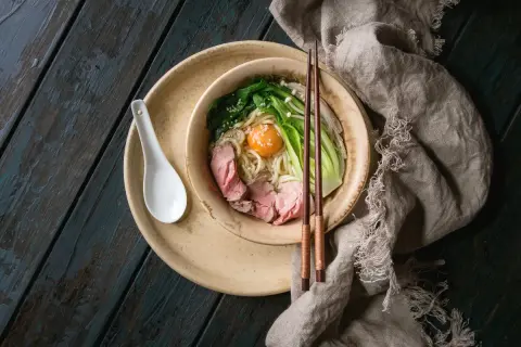 Schüssel mit Udon-Nudeln, Rindfleisch, Gemüse und Ei. Ein gesundes Gericht, das Lust auf mehr macht.