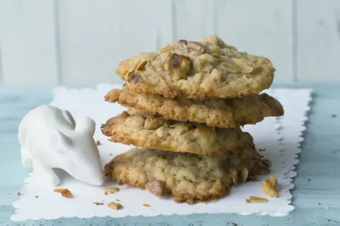 Ein Stapel leckerer cookies mit haferflocken und schokolade, daneben eine kleine weiße Maus-Dekoration.