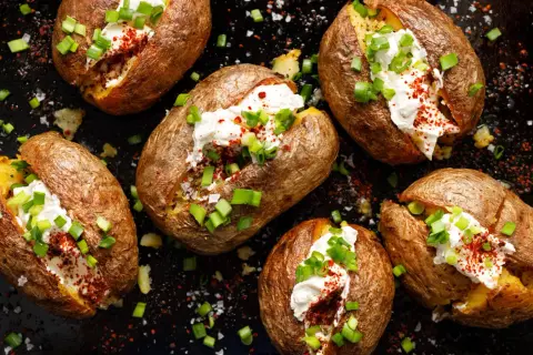 Mehrere gebackene Kartoffeln, gefüllt mit saurer Sahne, Schnittlauch und Paprikapulver. Ein wahrhaft "jacked potato" Genuss!