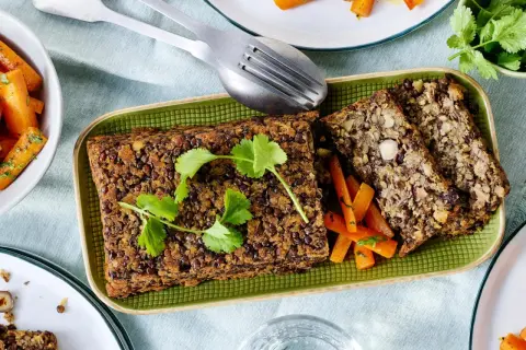 Herzhafte Linsen-Nuss-Braten, perfekt für vegetarische Rezepte Weihnachten. Dazu karamellisierte Karotten und frische Kräuter.