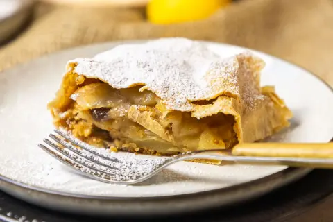 Ein Stück Apfelstrudel, bestäubt mit Puderzucker, wartet auf dich. Dieses apfelstrudel rezept original ist ein Genuss.