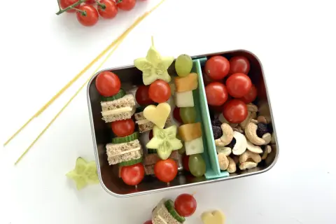 Bento-Box mit Spießen aus Mini-Sandwiches, Gurkensternen, Tomaten und Käseherzen. Ein tolles bento rezept für Kinder.