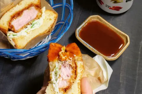 Ein saftiges Katsu Sando mit knuspriger Panade, Kohl und Sauce. Perfekt für einen schnellen, leckeren Snack.