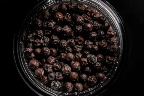 Nahaufnahme eines Glases mit fermentiertem Pfeffer, der leicht mit Salz bestreut ist.
