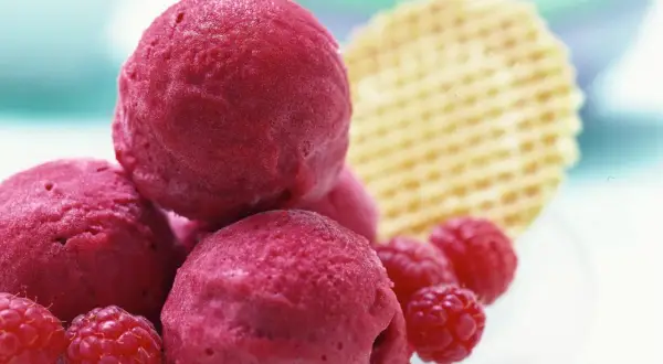 Himbeer Sorbet Kugeln mit frischen Himbeeren und Waffel. Ein erfrischender Genuss für heiße Tage.