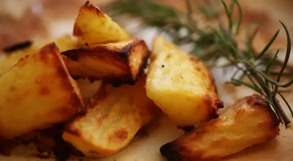 Knusprige Kartoffeln aus dem Ofen, goldbraun und mit Rosmarin verfeinert, verlocken zum Zugreifen.