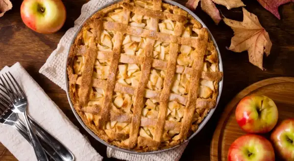 Goldbrauner Apfelkuchen mit Gittermuster, bereit zum Servieren. Ein perfektes apple pie rezept für gemütliche Herbsttage.