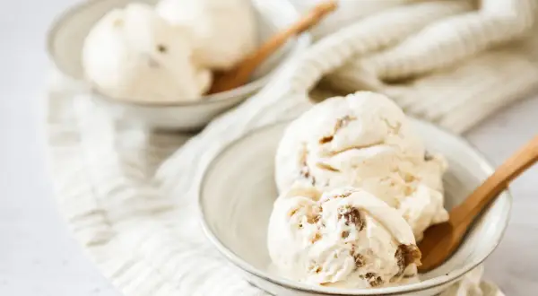 Cremiges Malaga Eis mit Rosinen, perfekt für ein selbstgemachtes Malaga Eis Rezept. Serviert in Schalen mit Holzlöffeln.