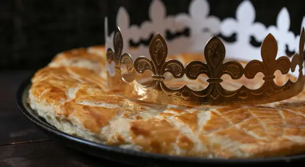 Goldene Krone auf einer goldbraunen Galette des Rois. Wer findet die Bohne und wird König?