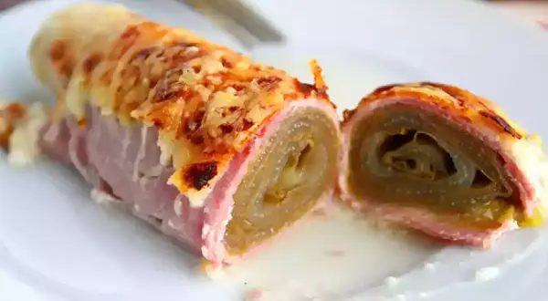 Endives au jambon, überbacken mit Käse, auf einem Teller serviert. Ein köstliches Gericht, das zum Genießen einlädt.