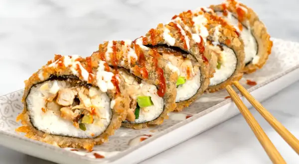 Knuspriges Sushi mit Hähnchen und Gemüse, beträufelt mit Saucen. Ein Genuss für die Sinne!