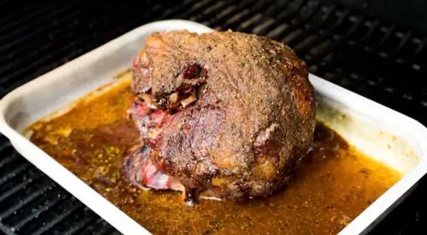 Ein saftiger Lammbraten mit knuspriger Kruste in einer Bratpfanne, bereit für ein köstliches Lammbraten Rezept.