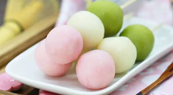 Bunte Hanami Dango auf einem Teller, bereit zum Genießen.