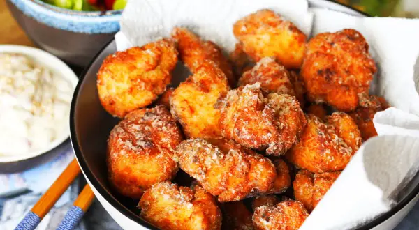 Knuspriges Chicken Karaage in einer Schüssel, daneben eine Dip-Schale und Salat. Perfekt für einen Snack!