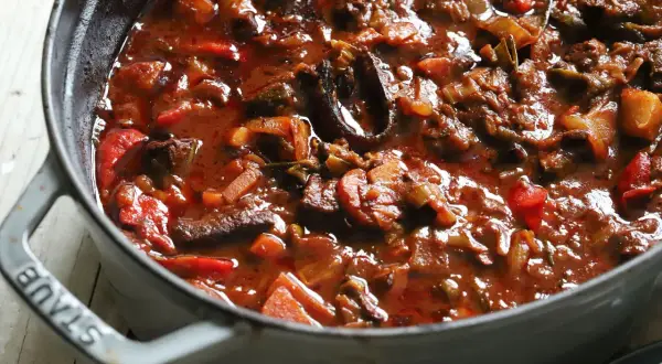 Herzhaftes Gulasch mit Paprika und Zwiebeln, eine köstliche Daube Provençale, dampft in einem grauen Gusseisentopf.