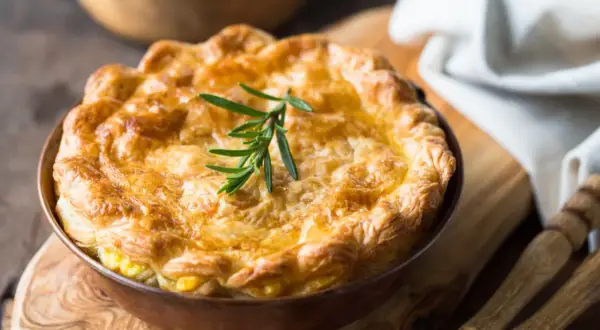 Goldbrauner, knuspriger Pot Pie mit Rosmarinzweig, bereit zum Servieren.