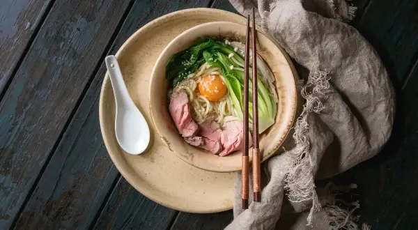 Schüssel mit Udon-Nudeln, Rindfleisch, Gemüse und Ei. Ein gesundes Gericht, das Lust auf mehr macht.