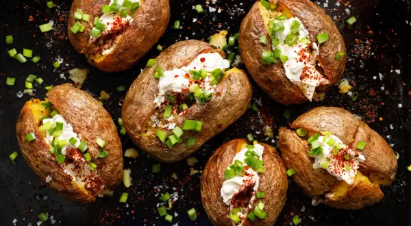 Mehrere gebackene Kartoffeln, gefüllt mit saurer Sahne, Schnittlauch und Paprikapulver. Ein wahrhaft "jacked potato" Genuss!