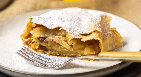 Ein Stück Apfelstrudel, bestäubt mit Puderzucker, wartet auf dich. Dieses apfelstrudel rezept original ist ein Genuss.