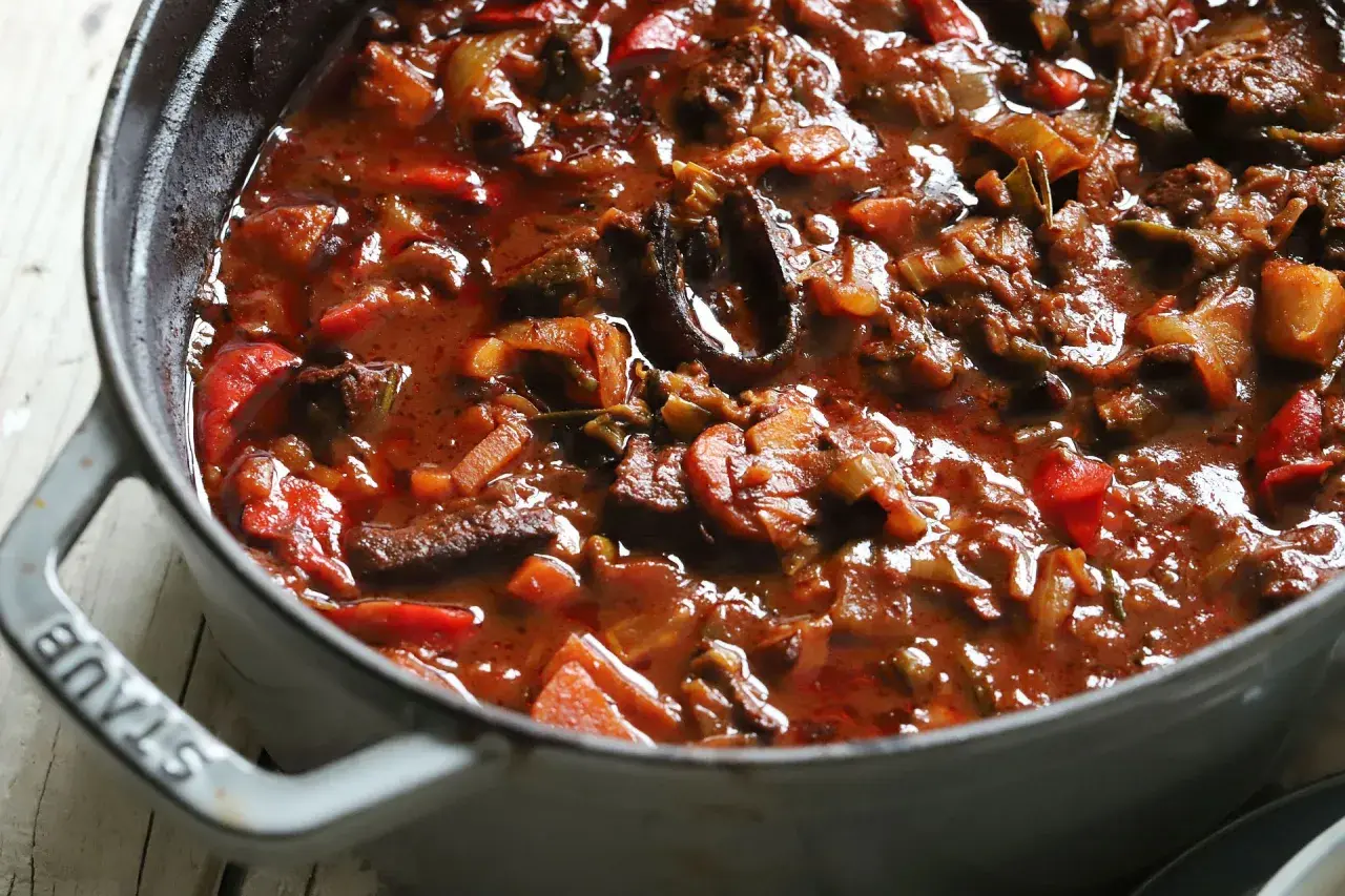 Herzhaftes Gulasch mit Paprika und Zwiebeln, eine köstliche Daube Provençale, dampft in einem grauen Gusseisentopf.