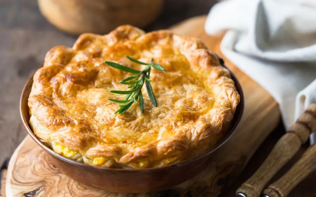 Goldbrauner, knuspriger Pot Pie mit Rosmarinzweig, bereit zum Servieren.