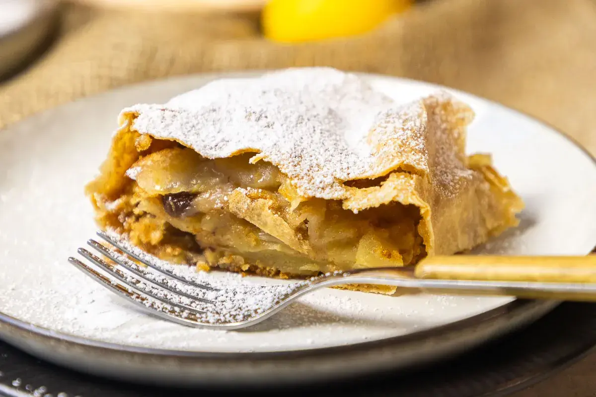 Ein Stück Apfelstrudel, bestäubt mit Puderzucker, wartet auf dich. Dieses apfelstrudel rezept original ist ein Genuss.