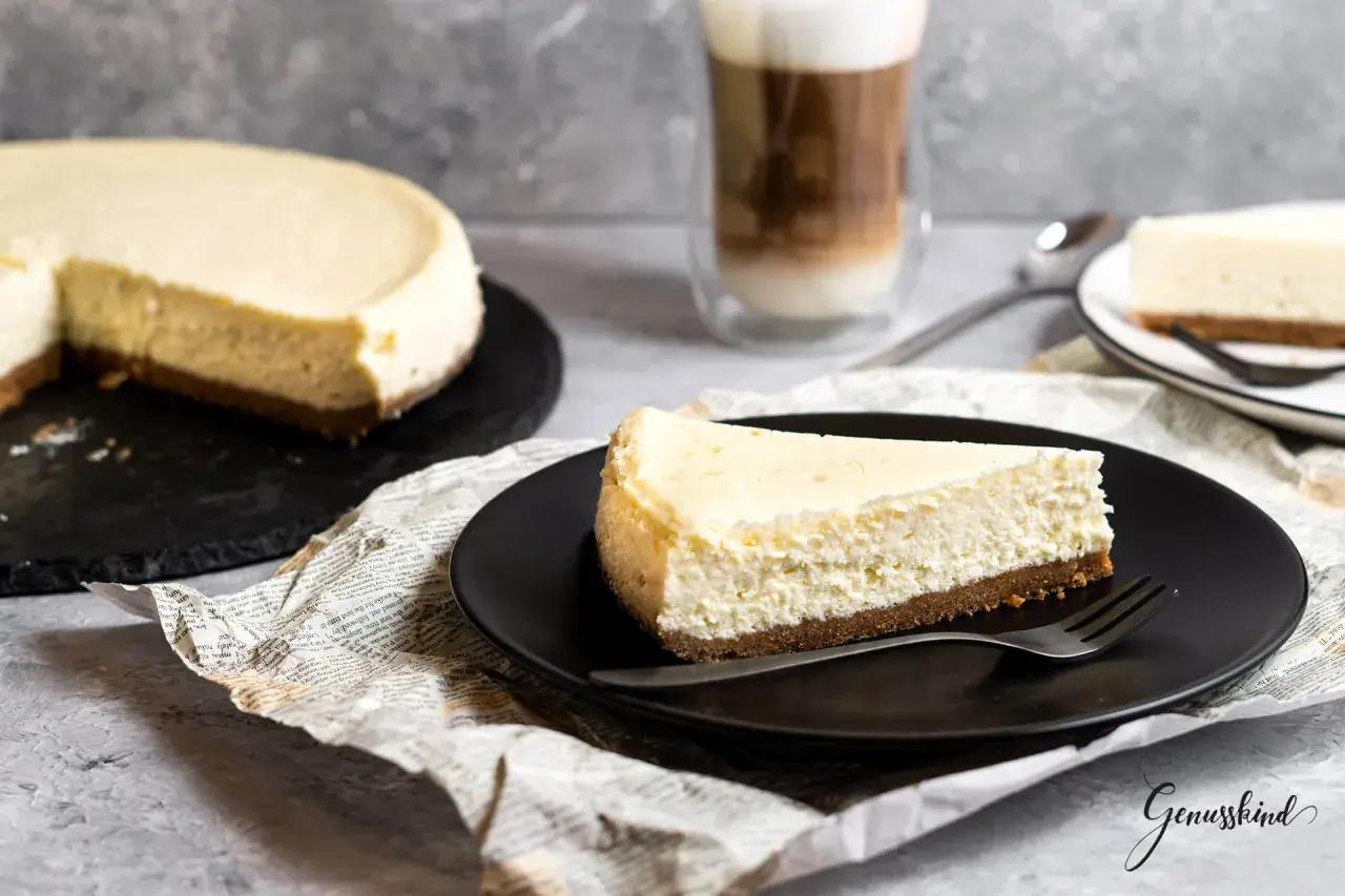 Ein Stück cremiger American Cheesecake, perfekt für das original american cheesecake rezept. Dazu ein Latte Macchiato.