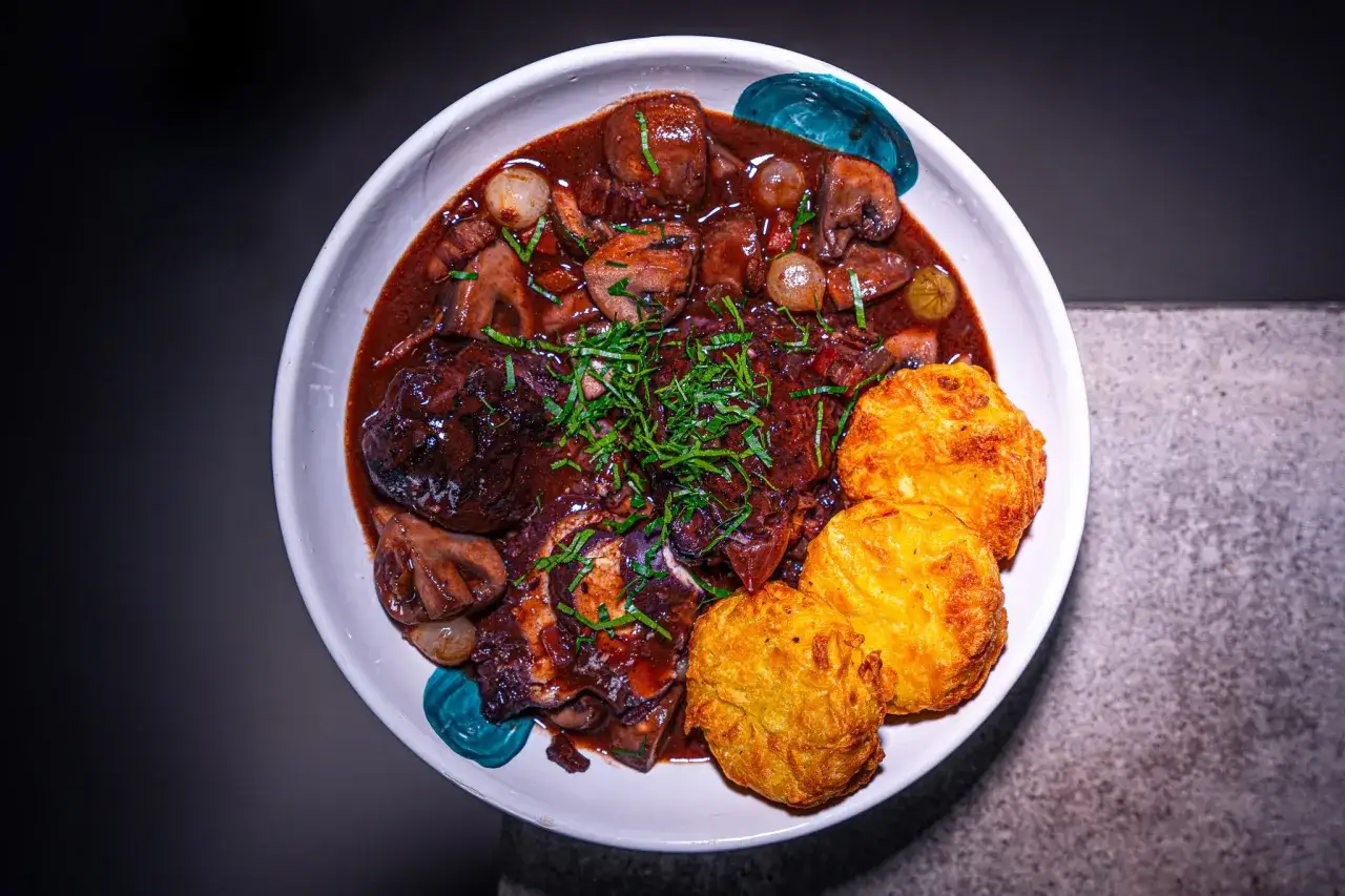 Ein k&ouml;stliches Coq au Vin Rezept original: H&auml;hnchenteile in Rotwein geschmort mit Champignons, Perlzwiebeln und drei goldbraunen Kartoffelr&ouml;sti.