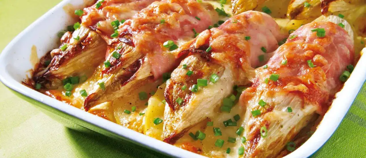 Endives au jambon, &uuml;berbacken mit K&auml;se und Schinken, garniert mit Schnittlauch. Ein k&ouml;stliches Gericht aus dem Ofen.